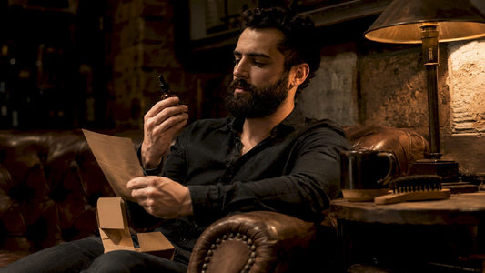 Man inspecting vegan beard oil label at kitchen table
