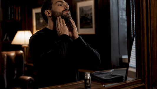 Man applying beard oil in bathroom