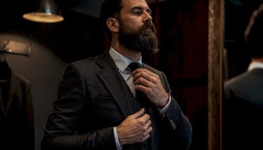 Man grooming beard while wearing suit