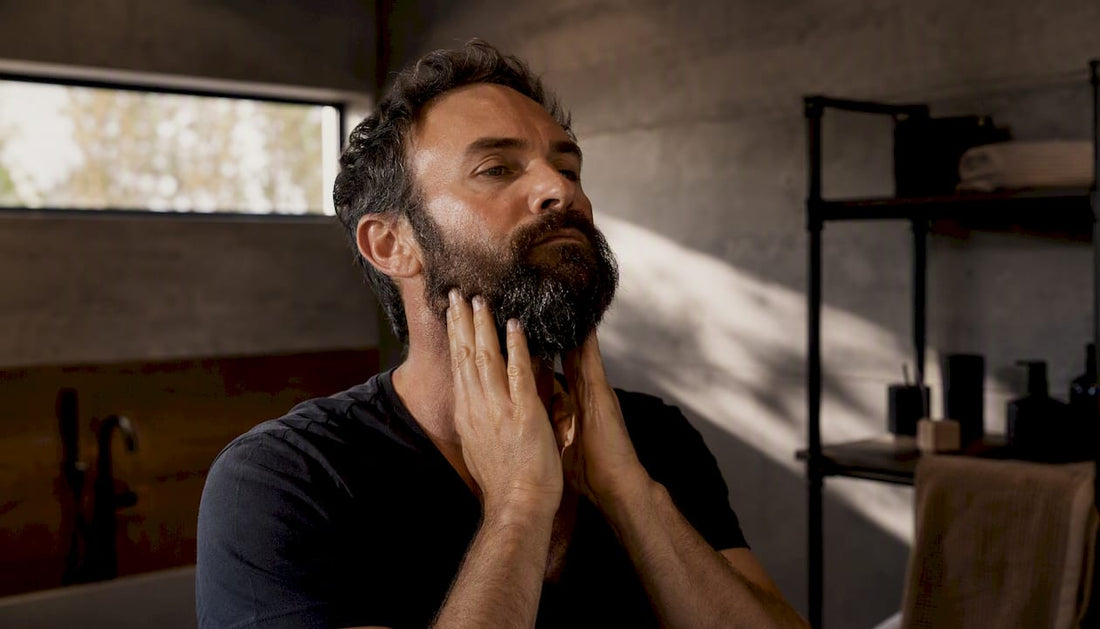 Man applying beard oil to damp beard