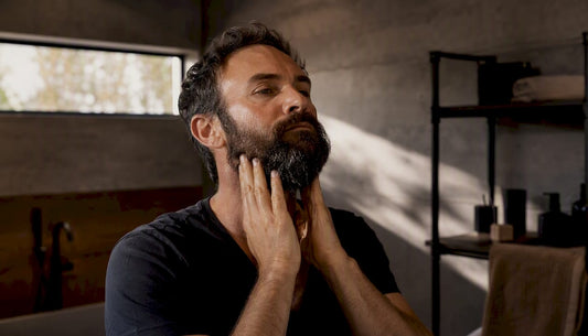 Man applying beard oil to damp beard