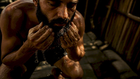 Man rinsing coarse beard with lukewarm water