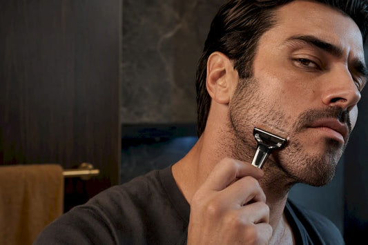 Man carefully shaving coarse beard stubble